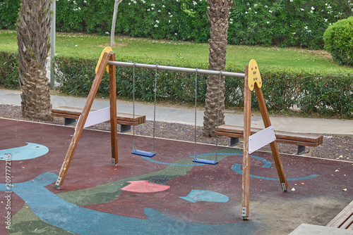 Empty playground swings in urban park without children