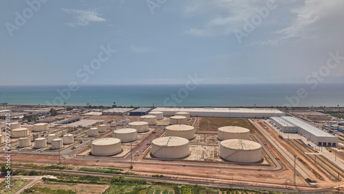 Aerial view of oil storage tanks and industrial infrastructure by sea