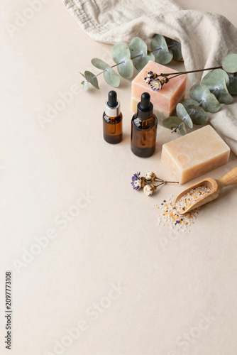Premium Flat Lay of Natural Herbal Skincare Products with Botanical Soaps, Amber Serum Bottles, Bath Salts, and Fresh Greenery on Soft Pastel Background for Clean Beauty and Wellness Branding