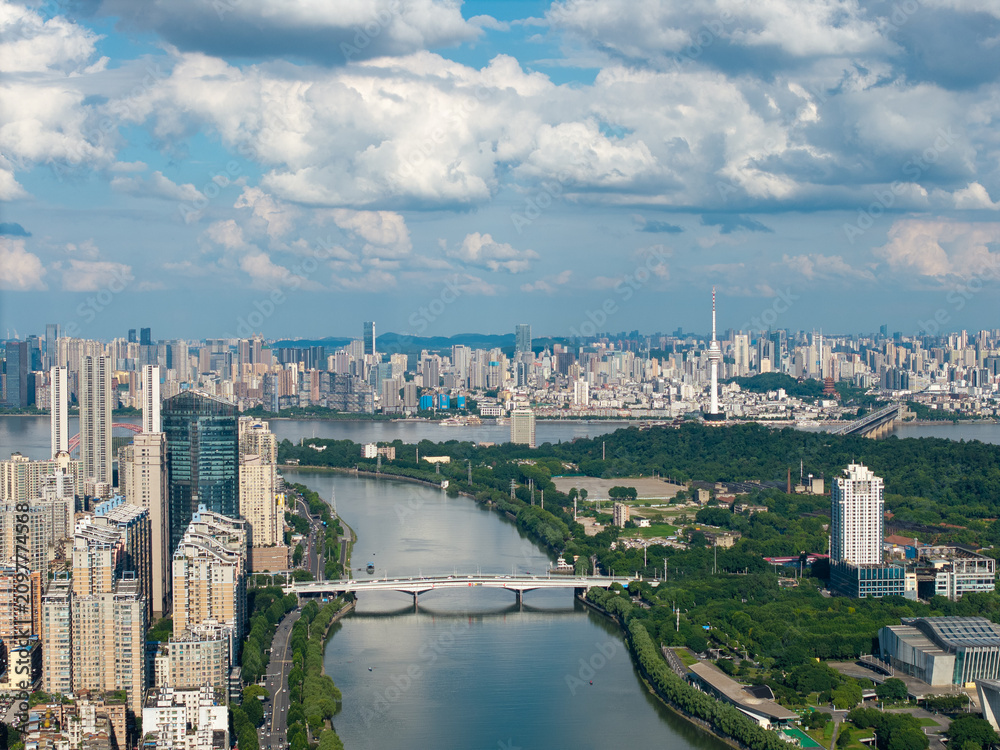 Fototapeta premium A high angle aerial view shows the modern city skyline and river landscape during a bright sunny day in Wuhan China