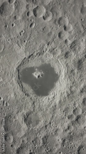 A hand touches the surface of the moon, showing craters and texture in close view