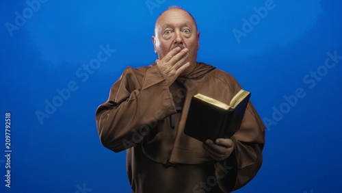 Photos Man holding bible and clutching cross with hand, sometimes covering mouth in a studio portrait session; reverence contemplation
