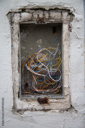 Bild auf Leinwand Ancien coffret électrique mural endommagé avec enchevêtrement de câbles électriq