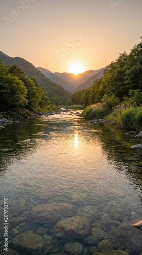 Gentle river flowing through a valley with lush green trees and mountains during sunset