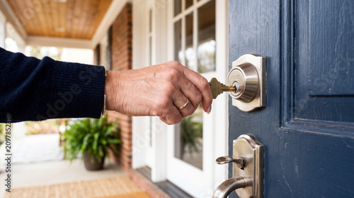 keyhole home owner putting key into modern front door lock