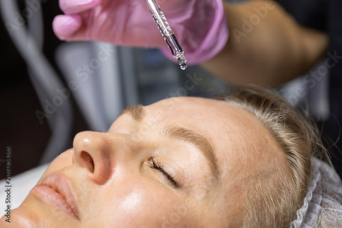 Fotografie Close-up of a facial serum drop applied before a professional skincare treatment, highlighting skin hydration and cosmetic facial care in a beauty clinic