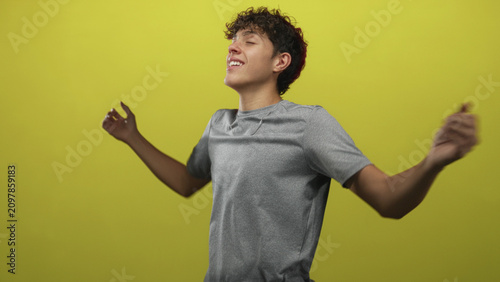 Bild auf Leinwand Teenage boy smiling with open hands and arms outstretched in studio, eyes closed and relaxed; joy freedom