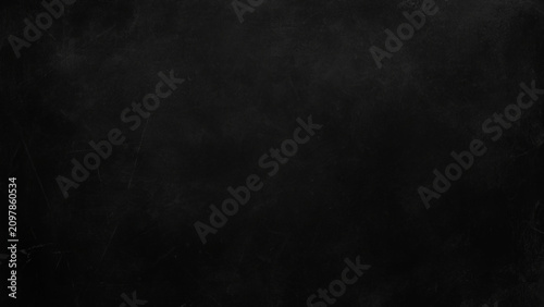 Dark textured surface with scratches and marks on a black background
