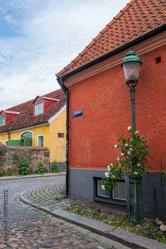Cobblestone street with colorful houses and lamppost in Lund Sweden
