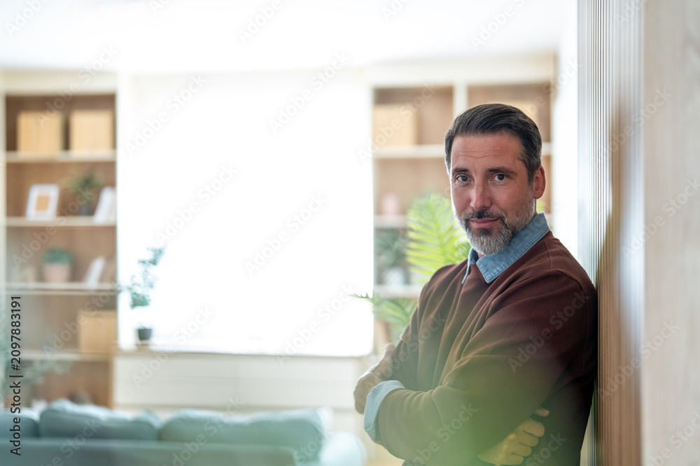 Fototapeta premium Confident middle-aged man smiling in modern home
