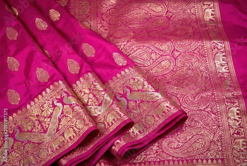 Luxurious pink silk fabric with intricate gold zari embroidery and traditional Indian elephant and peacock motifs