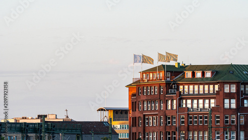 Fotografía Classic Red Brick Corporate Building with Flags at Sunset