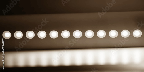 Foto A row of glowing LED lights casts a warm, diffused illumination in a close-up, abstract shot, highlighting the clean lines and modern design of a surface