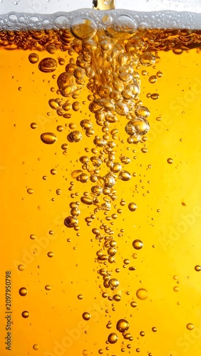 A golden liquid with rising bubbles and a layer of foam at the top