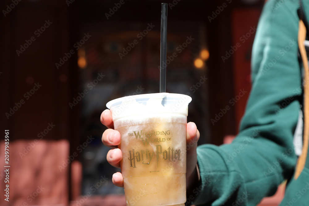 Fototapeta premium Person holding frozen butterbeer from The Wizarding World of Harry Potter