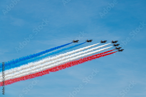 Patrouille de France Alpha Jets cross New York sky. Nine aircraft release blue, white and red smoke during the Sail4th 250 aerial review.