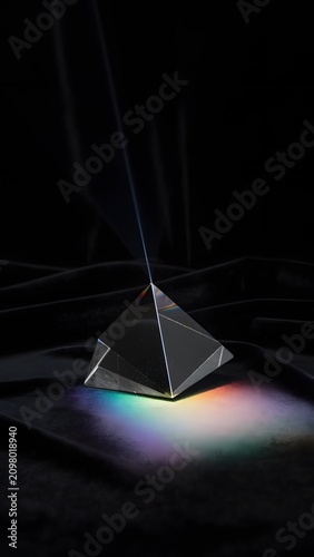 Single Perfect Glowing Glass Prism Resting on a Black Velvet Cloth Bending a Ray of Light Representing Physics Optics, Spectrum Dispersion, and Creative Scientific Discovery Concept