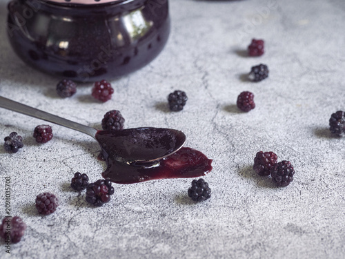 spoonful of homemade blackberry jam accompanied by fresh blackberries