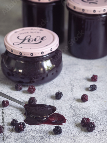 spoonful of homemade blackberry jam accompanied by fresh blackberries