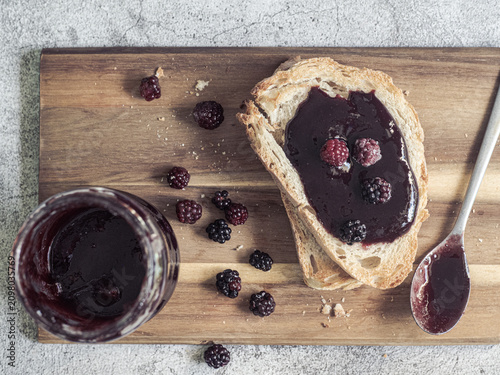 Blackberry jam spread on toast with homemade preserves and fresh berries