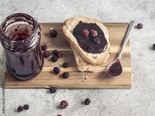 Homemade blackberry jam on toast with fresh blackberries and rustic breakfast scene