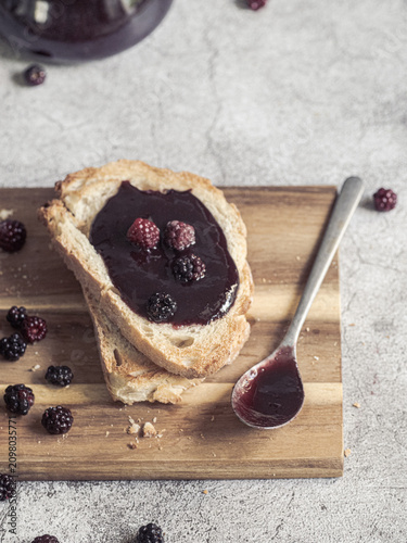 Blackberry jam spread on toast with homemade preserves and fresh berries