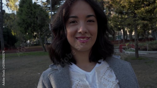 Beautiful latina woman looking at camera in city park