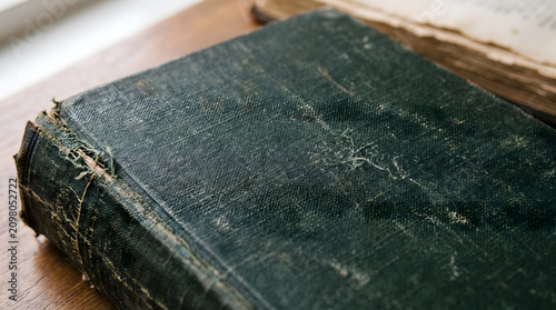 Worn Dark Green Vintage Book Cover on Wooden Table