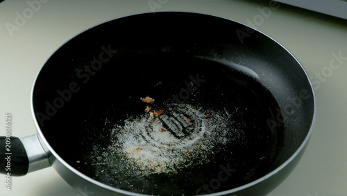 Close-Up of Worn Nonstick Frying Pan with Scratched PTFE (Teflon) Surface Showing Signs of Heavy Use and Cookware Deterioration