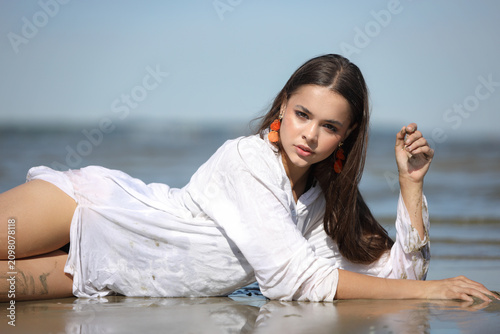 Beautiful Young Woman Relaxing on Sunny Beach Shore