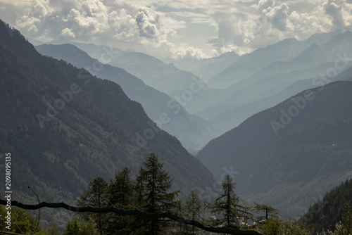 Alpine valley with misty mountain ranges and forest
