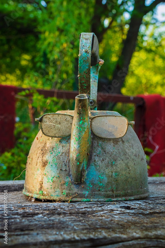The glasses on the old teapot resemble a human face with a nose. Example of apophenia and pareidolia. Old vintage item