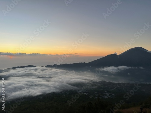 Obraz na płótnie Sunrise over sea of clouds from Mount Batur with volcanic mountain of Mount Agun