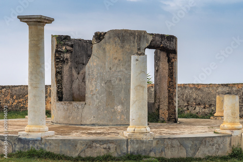 Cuadro en lienzo Ancient architectural ruins with classical columns against a clear sky, showcasing historical dilapidation and decay
