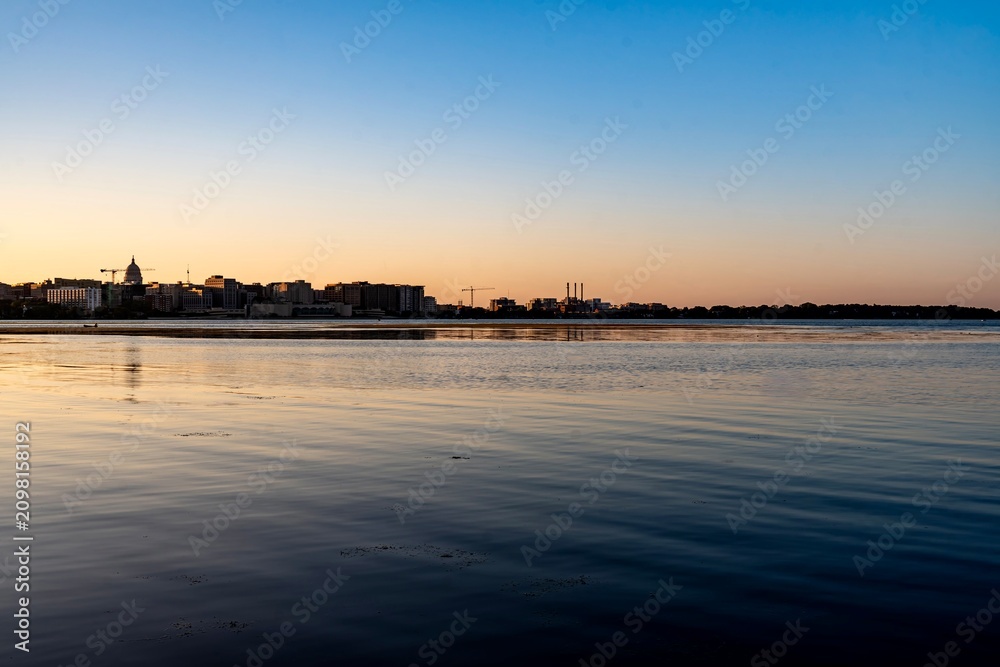 Obraz premium Lake Monona in Madison in front downtown and the state capital building at Dusk
