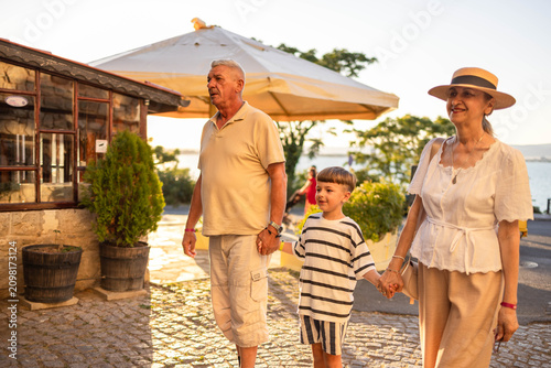 Quadro em tela Grandparents and grandson exploring the old town