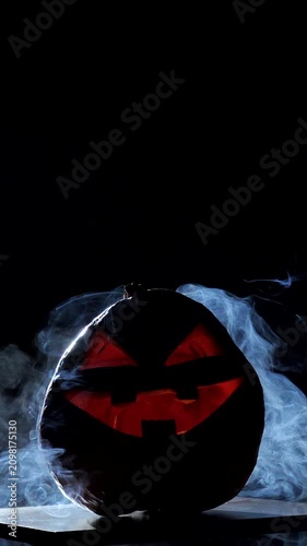 scary pumpkin, Jack O Lantern for Halloween with eyes glowing inside on a black background.