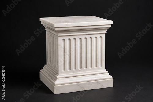 Classical white marble pedestal with fluted details on dark background.