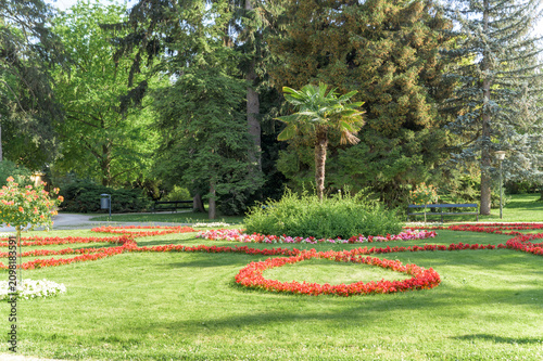 Obraz na plátně The image showcases a stunning flower garden at Schonbrunn Palace in Austria featuring vibrant blooms in various colors including reds, yellows, and pinks