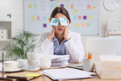 Overworked young woman with...