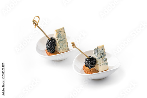 Appetizer with blue cheese, blackberries, cookies, isolated on white background. Catering food, canape and snacks, close up