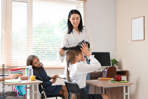 Female teacher putting VR g...