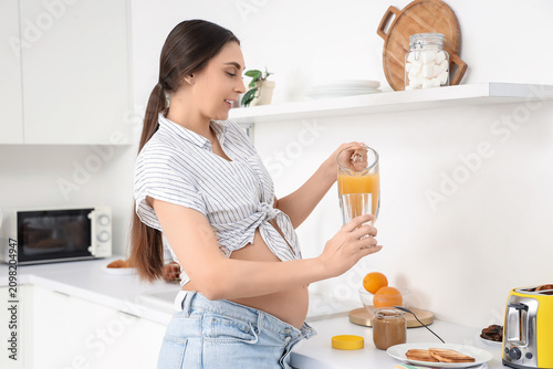 Young pregnant woman pourin...