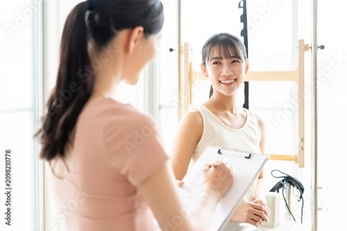 ピラティススタジオで話を聞く女性