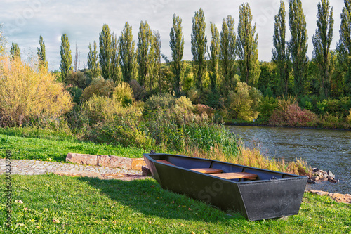 Tableau sur toile Boat on the grass on the river bank