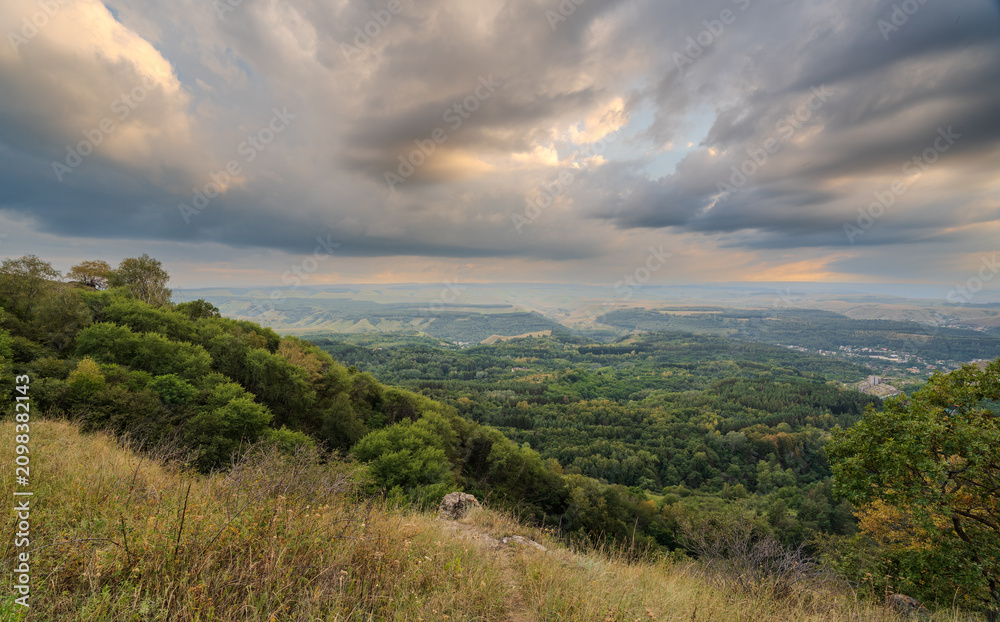 Obraz premium Layers of green mountains and hills in the haze during sunset. Panoramic View of Green hills and Meadow.
