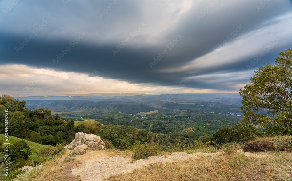 Fototapeta premium A mountain range covered in the wild woods illuminated by the golden light of the setting sun. A natural Park reserve or hunting grounds. Recreational outdoor tourism