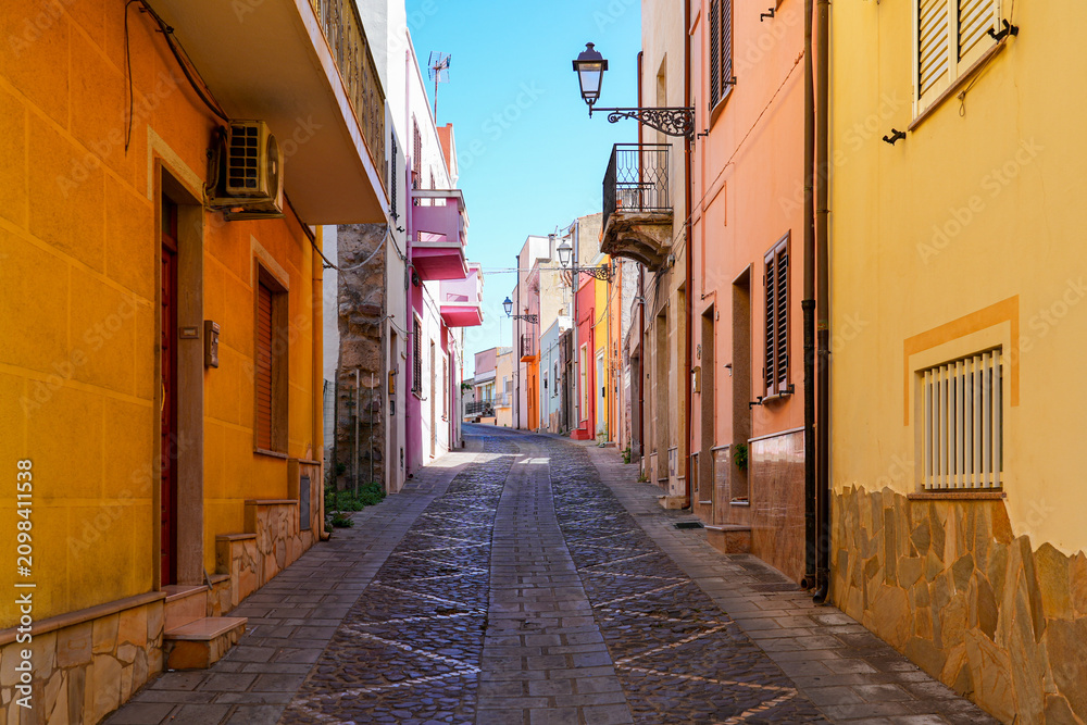 Fototapeta premium Traditional narrow street with colorful houses in the town of Sant'Antioco, Sardinia, Italy