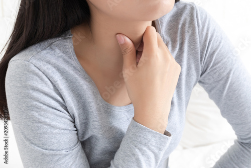 Foto A young Chinese woman with a sore throat in the bedroom