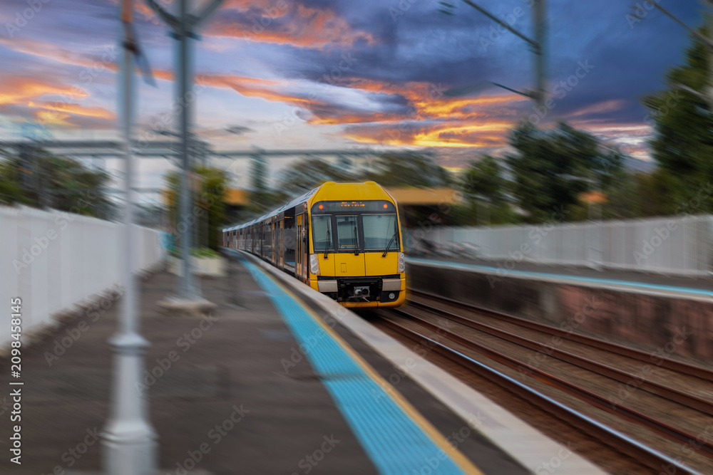 Obraz premium Passenger Train going through Lewisham Train Station at Sunset a suburban Sydney train Station in Sydney NSW Australia